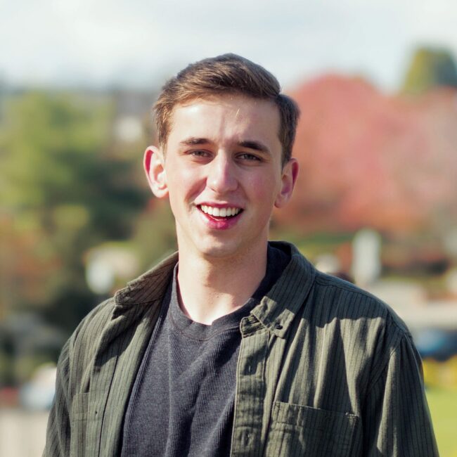 Male student in a flannel standing outside.