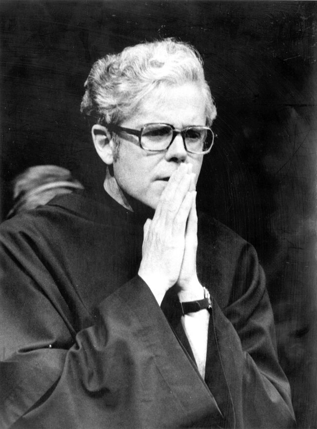 Black and white photo of Fr. Michael Scanlan, TOR, praying in glasses and a friar habit.