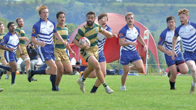 Baron rugby player John Thibault sprints past opposing players.