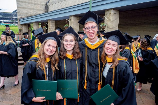 Happy Franciscan University graduates celebrate with friends and family after a job well done.