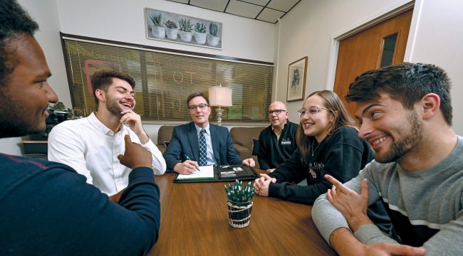 A group in a conference room chatting with each other.