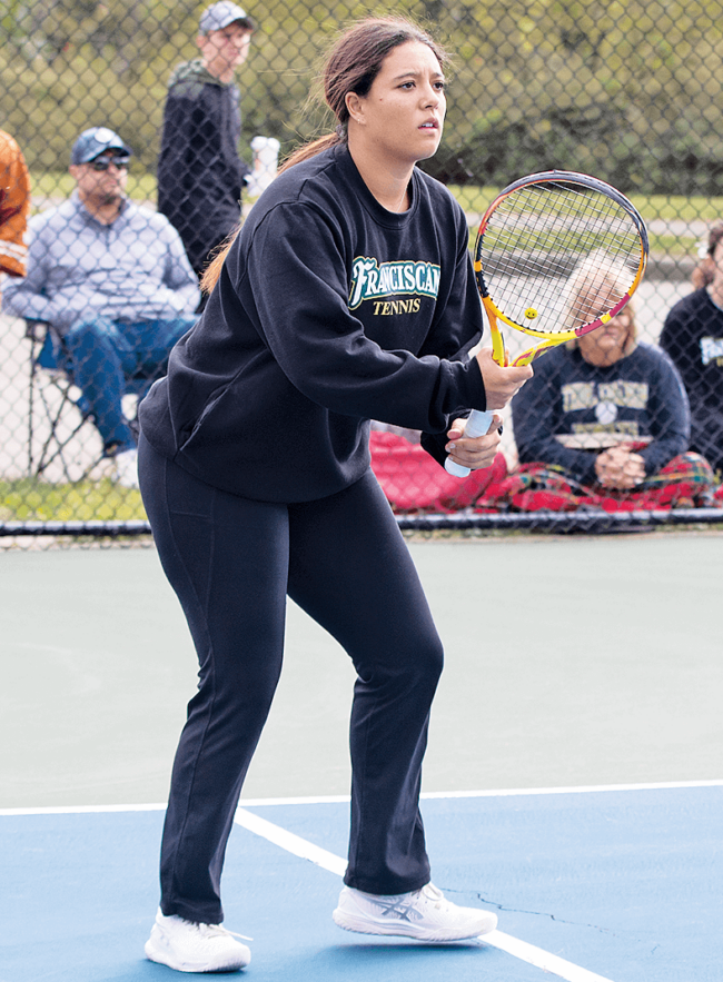 A woman holding a tennis racket on a court.