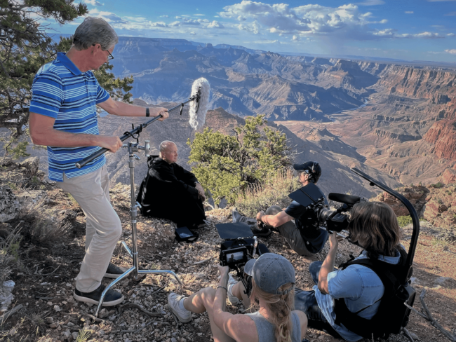 A film crew filming Fr. Dave Pivonka doing an interview in front of a canyon.