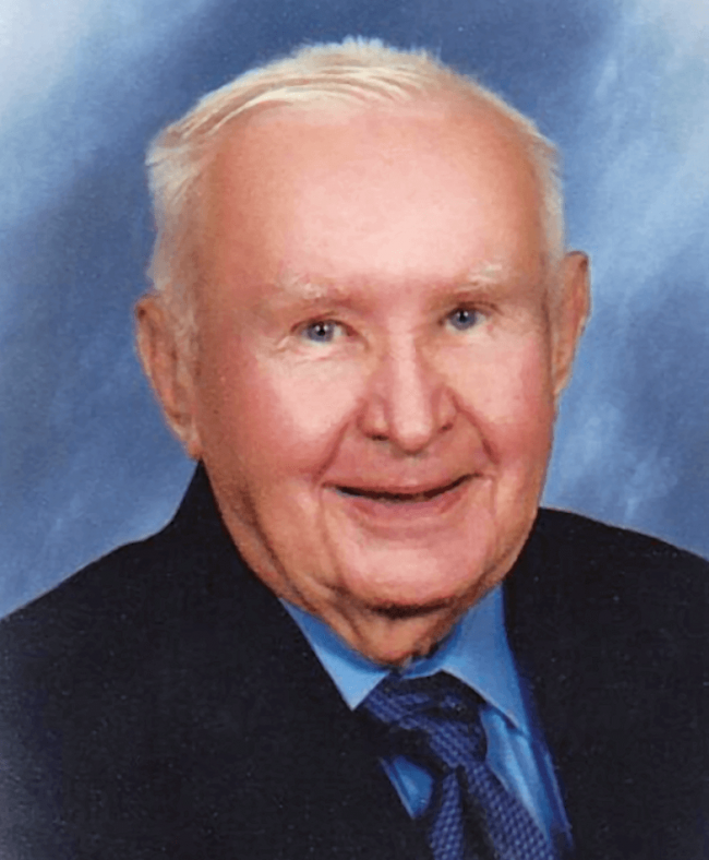 A man in a suit with a blue background.
