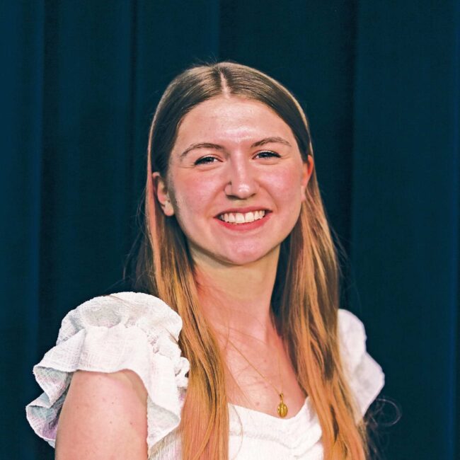 Ava Quaale in a white shirt with a navy background.