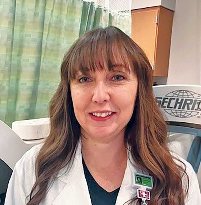 Crystal Boyd in a doctor's lab coat in a hospital room.