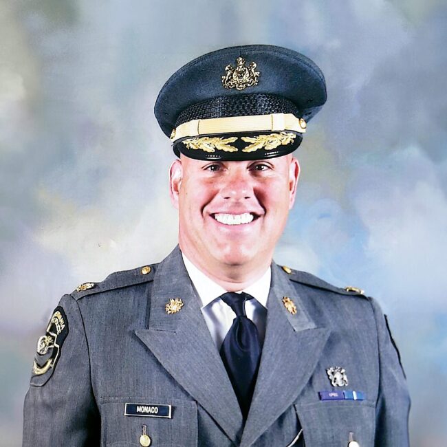 Frank Monaco in military garb in front of a grayish blue background.