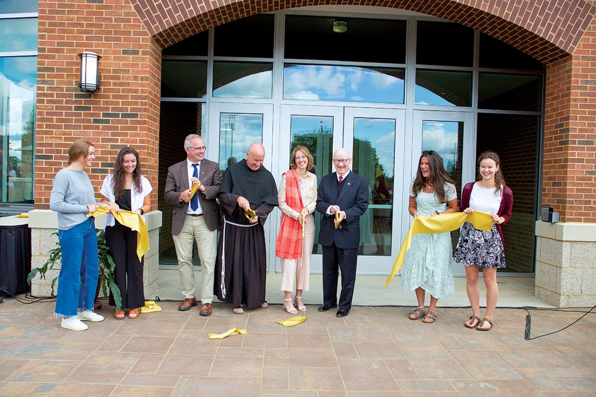 Students assist as Vice President for Academic Affairs Dr. Stephen Hildebrand, Fr. Dave Pivonka, TOR ’89, Dr. Christin Jungers, and Mickey Pohl cut the ribbon at the opening ceremony for Christ the Teacher Hall on August 21.