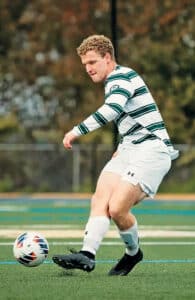 Aidan Henninger playing soccer on the field. 
