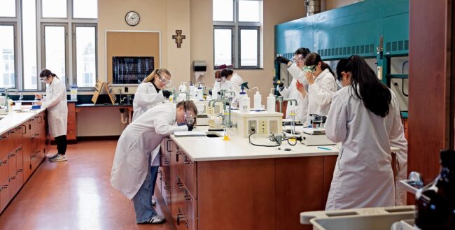 A group of scientist in lab coats doing experiments in a lab.