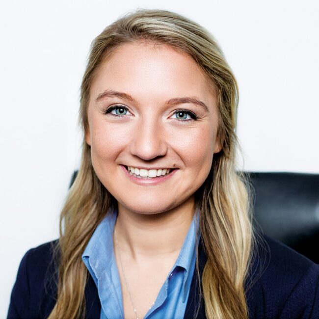 Headshot of Anne Foster in a professional outfit against a white background.