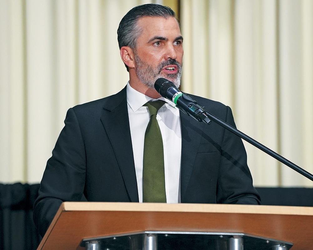 Cleveland Browns head coach Kevin Stefanski in a suit and tie speaking at a podium.