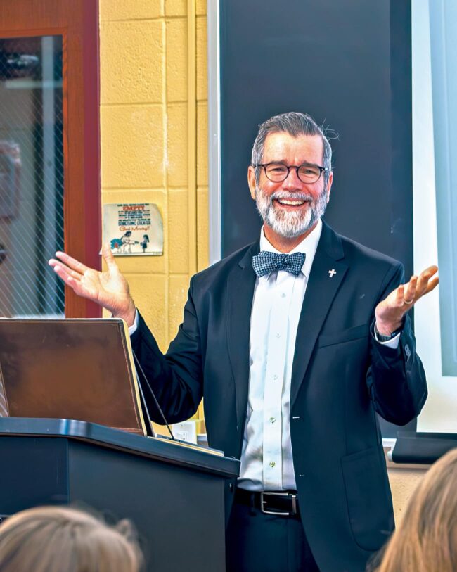 Dcn. Dr. Bob Rice, program director of Franciscan’s new DMin, stands at a podium speaking to students.
