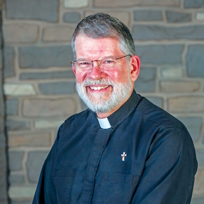 Headshot of Deacon Mark Erste in front of a brick background.