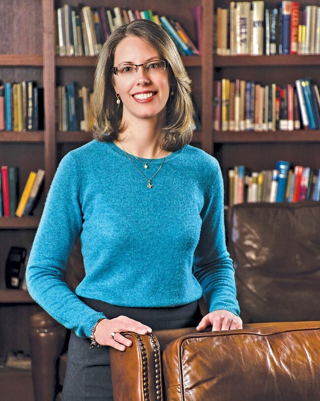 Headshot of Dr. Christin Jungers standing in front of a bookshelf.