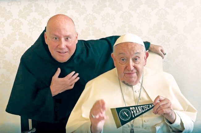 Pope Francis holding a small Franciscan University of Steubenville flag next to Fr. Dave Pivonka.
