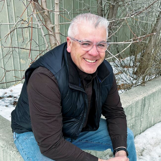 Robert Krueger in casual clothes sitting outside in winter.