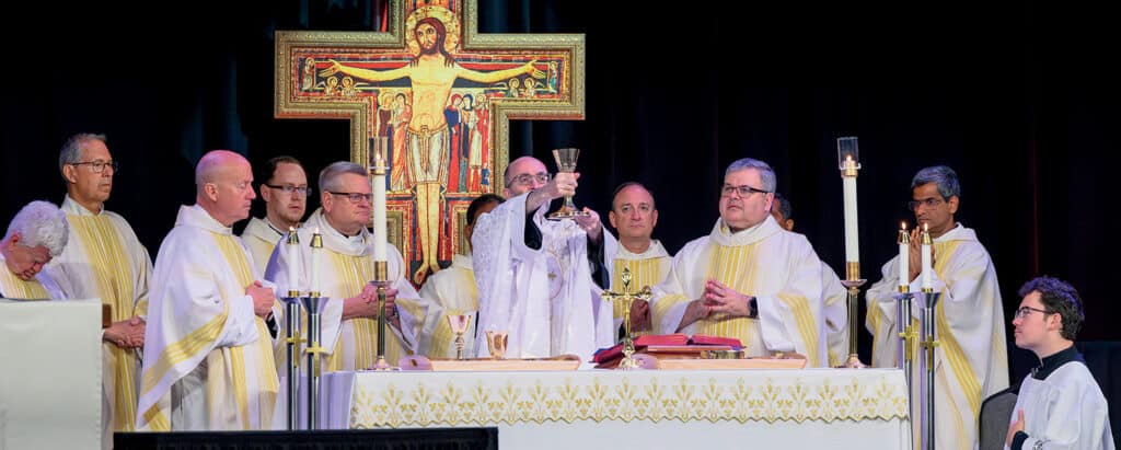 Fr. Jonathan St. André, TOR ’96, elevates the chalice at a Power and Purpose Conference Mass