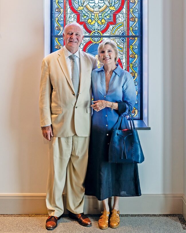 Kevin ’71 and Patti Mihm standing in front of a stain glass window.