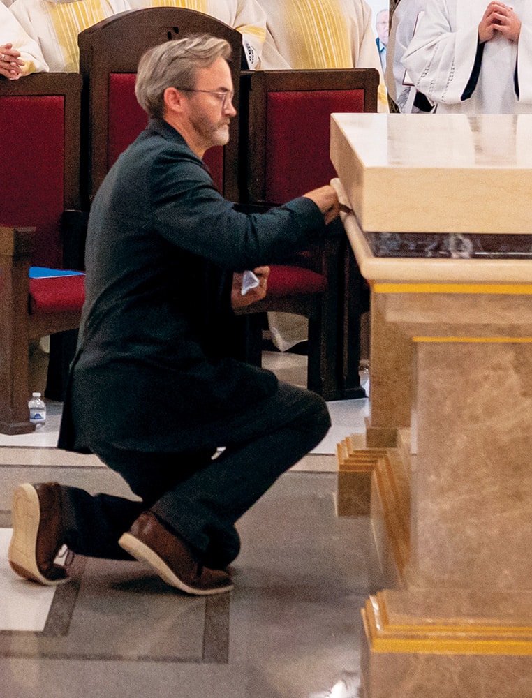 Steve Baker knees as he closes the aperture in the altar.