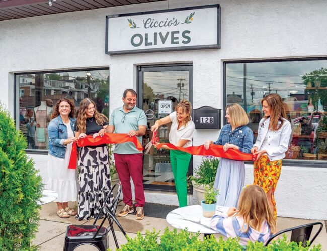 Ribbon-cutting outside the Ciccio’s Olives storefront, with several adults standing in front of the shop entrance.