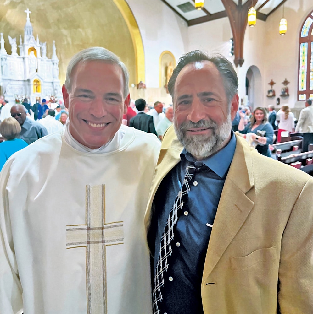 Deacon Rob Krall ’87 and Dr. Peter Colosi ’87 posing together inside a church after a liturgical service.