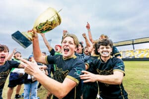 NCR Division III National Player of the Year Joseph Moleski raising the national championship trophy with Franciscan rugby teammates.