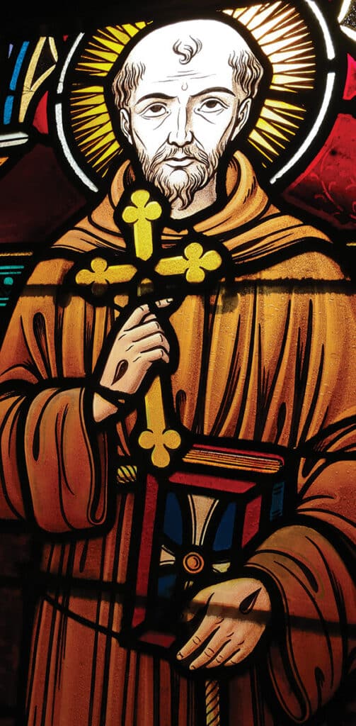 Stained glass window depicting St. Francis of Assisi with a cross.