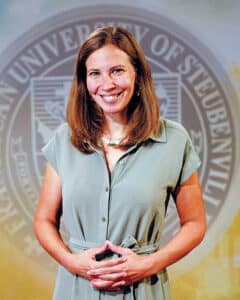 Portrait of Dr. Joanne Storm Gallagher in front of the university seal.