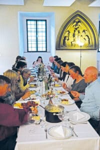 Students and guests sharing a meal together around a long table at Franciscan University.